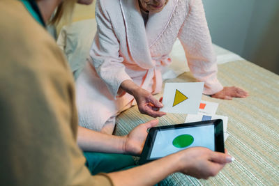 Nurse and senior patient using digital tablet in hospital