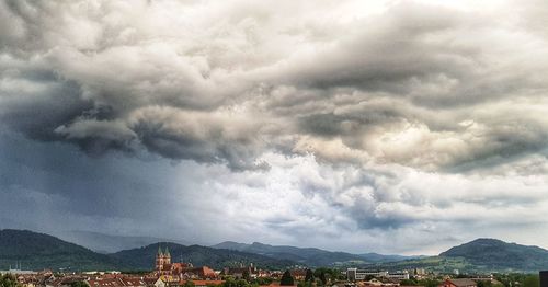 Aerial view of townscape against cloudy sky