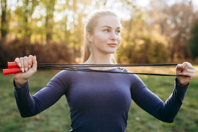 Training in the park, girl holding a skipping rope.