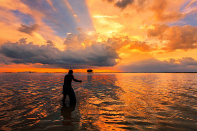 Rear view of man on beach during sunset