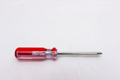 Close-up of red screwdriver on white table