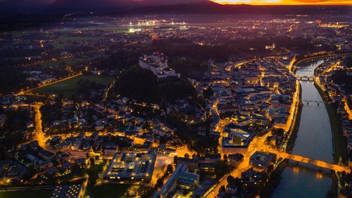 High angle view of city lit up at night