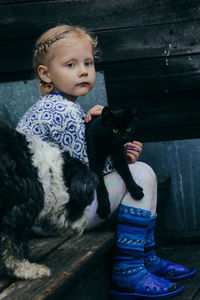 Full length of baby girl holding cat 