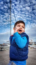 Boy standing by harbor