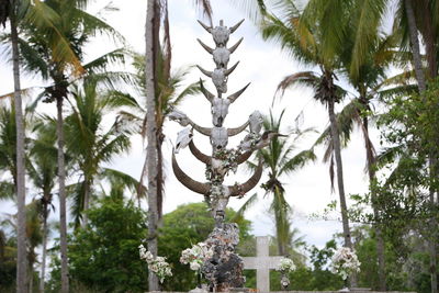 Low angle view of animal skeletons against palm trees