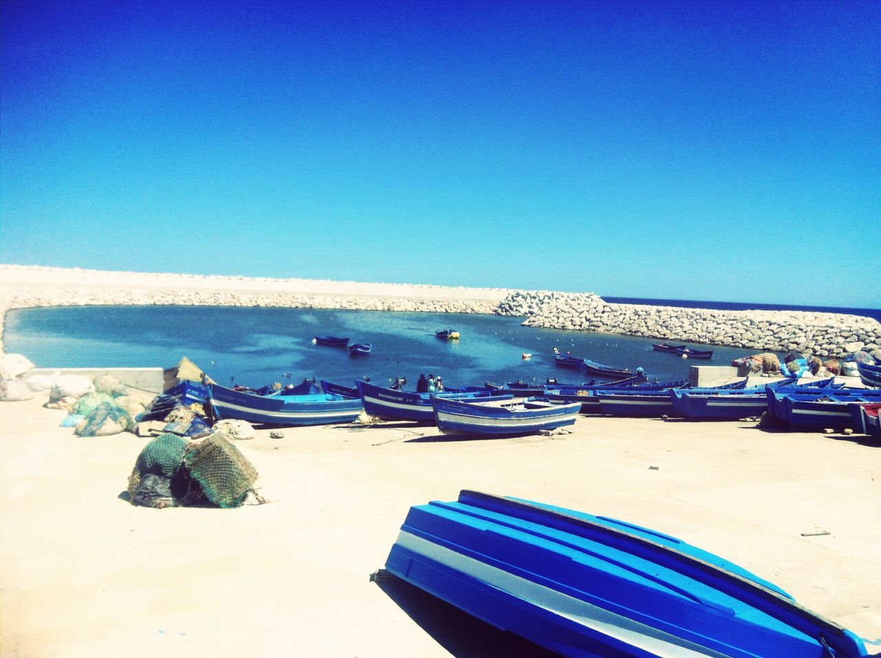 blue, clear sky, copy space, beach, sand, sea, beach umbrella, lounge chair, nautical vessel, transportation, boat, shore, absence, parasol, moored, mode of transport, chair, deck chair, day, vacations