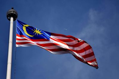 Low angle view of flag against blue sky