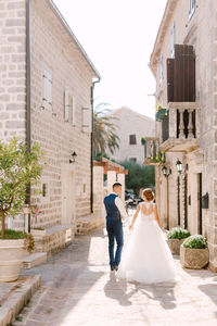 Couple walking on street amidst buildings