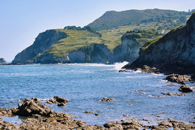 Scenic view of sea and mountains against sky