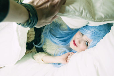 High angle portrait of cute girl lying on bed