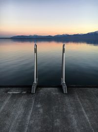 Jetty on lake against sky during sunset