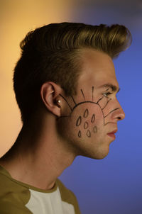 Side view of a young man with face paint