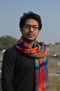 Portrait of young man standing against sky