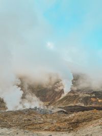 Smoke emitting from volcanic mountain against sky