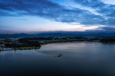 Scenic view of lake by city against sky