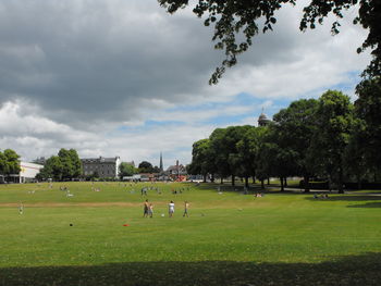 People playing in park against sky