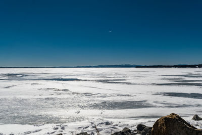 Scenic view of beach against clear blue sky