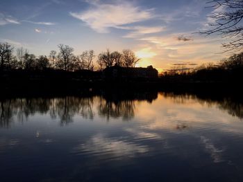 Reflection of trees in lake during sunset