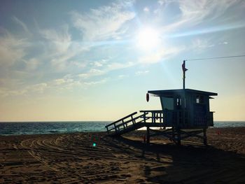 Lifeguard hut on beach against sky