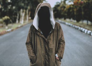 Digital composite image of invisible person wearing jacket on road