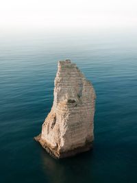 High angle view of rock formation in sea against sky