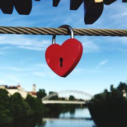 Close-up of padlocks on heart shape against sky
