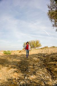 Full length of young woman against sky