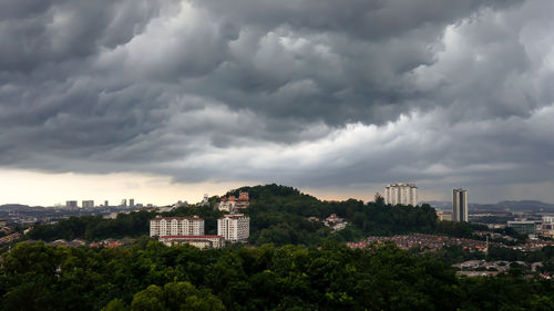 High angle view of buildings in city against cloudy sky