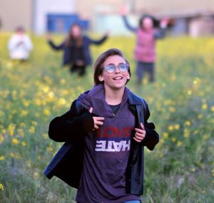 Portrait of smiling young woman standing on field