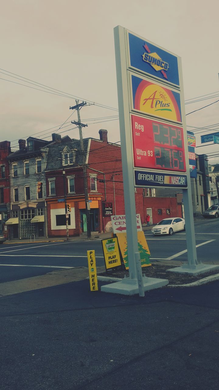 building exterior, architecture, built structure, text, western script, communication, city, clear sky, street, transportation, road, outdoors, day, sign, non-western script, information sign, no people, road sign, building, sky