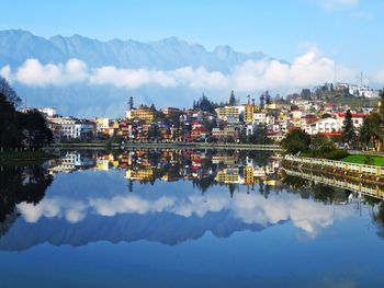 Reflection of buildings in lake against sky