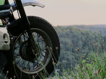 Close-up of tire track on field against sky