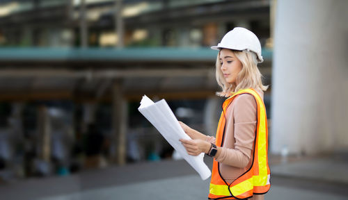 Side view of a young woman wearing engineer hat