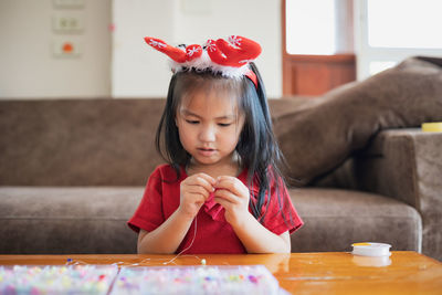 Cute girl making decoration on table