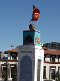 Low angle view of flags against buildings against clear blue sky