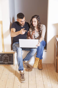 Portrait of siblings using laptop at home