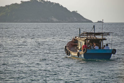 Boat sailing on sea against clear sky