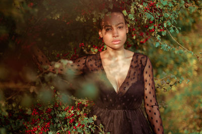 Portrait of woman standing against plants