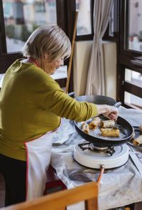 Senior woman preparing spanish christmas pastry pestinos