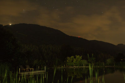 Scenic view of lake against sky at night