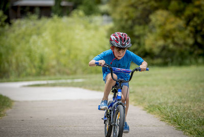 Boy riding bicycle on road