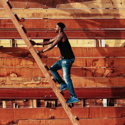 Full length of young man standing against brick wall