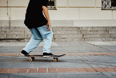 Skateboarder ride on skateboard at city street, close up