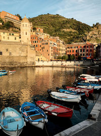 Boats moored at harbor by buildings in city