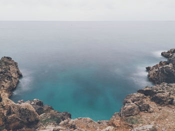 Rock formations by sea against sky