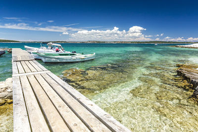 Boats moored on sea against sky