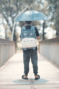 Rear view of woman holding umbrella