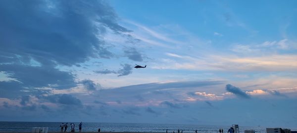 Airplane flying over sea against sky