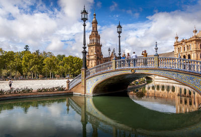Plaza de espana at seville, spain. arch bridge over river against sky