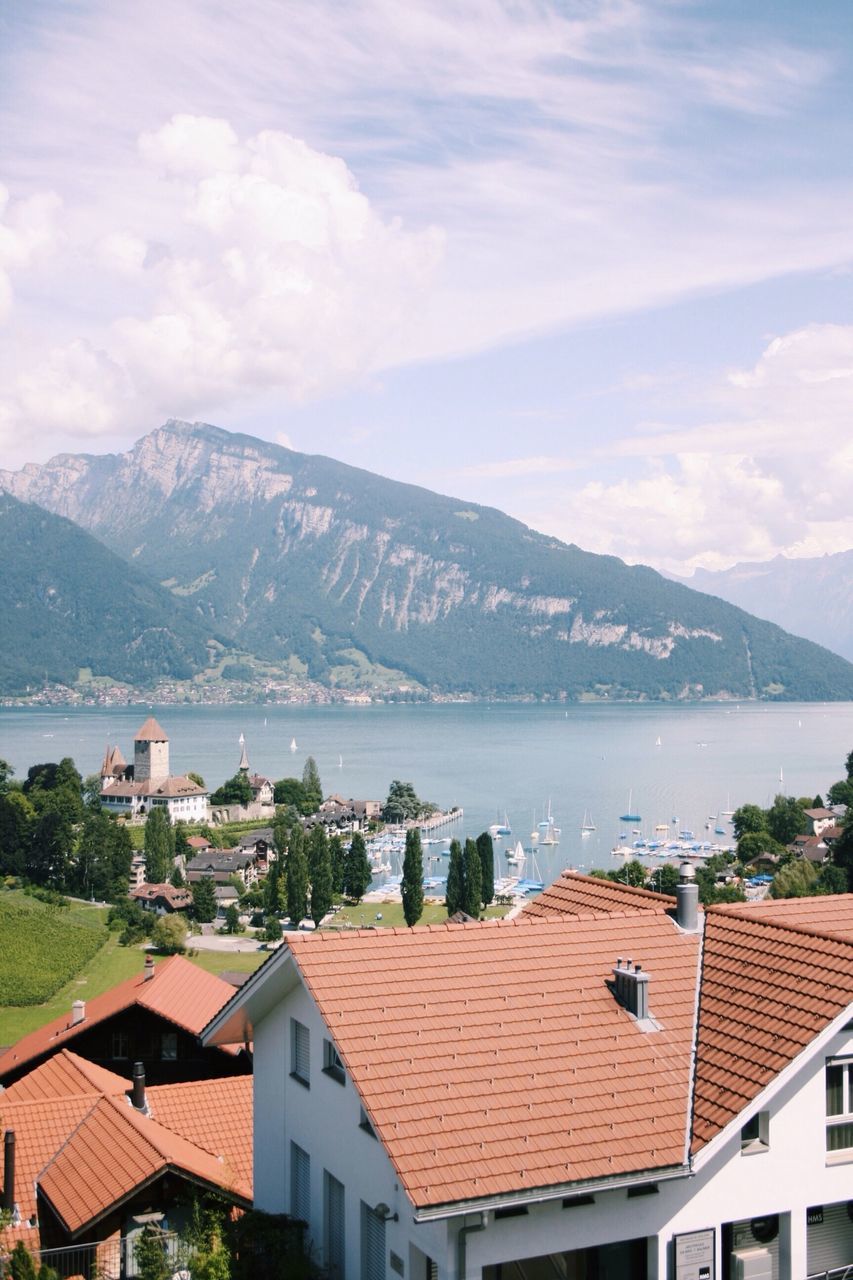 building exterior, architecture, mountain, built structure, house, mountain range, roof, sky, residential structure, town, residential building, townscape, high angle view, residential district, water, cloud - sky, scenics, tree, day, nature